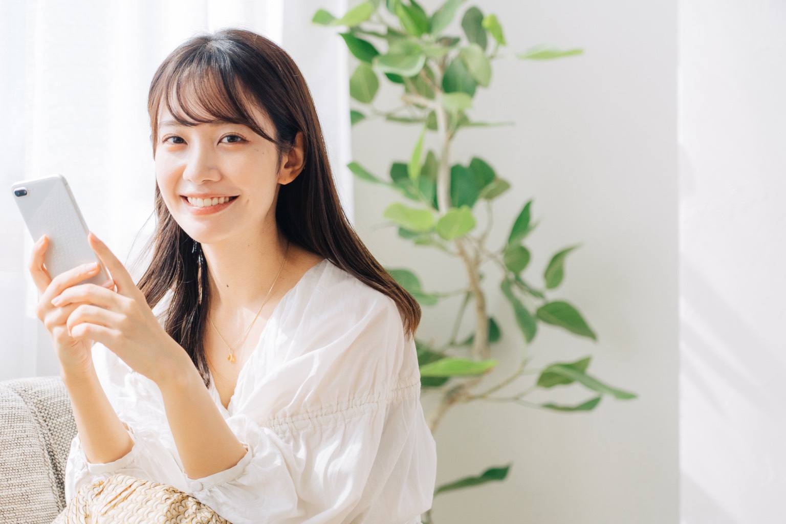 オンライン診察をするスマホを持つ女性